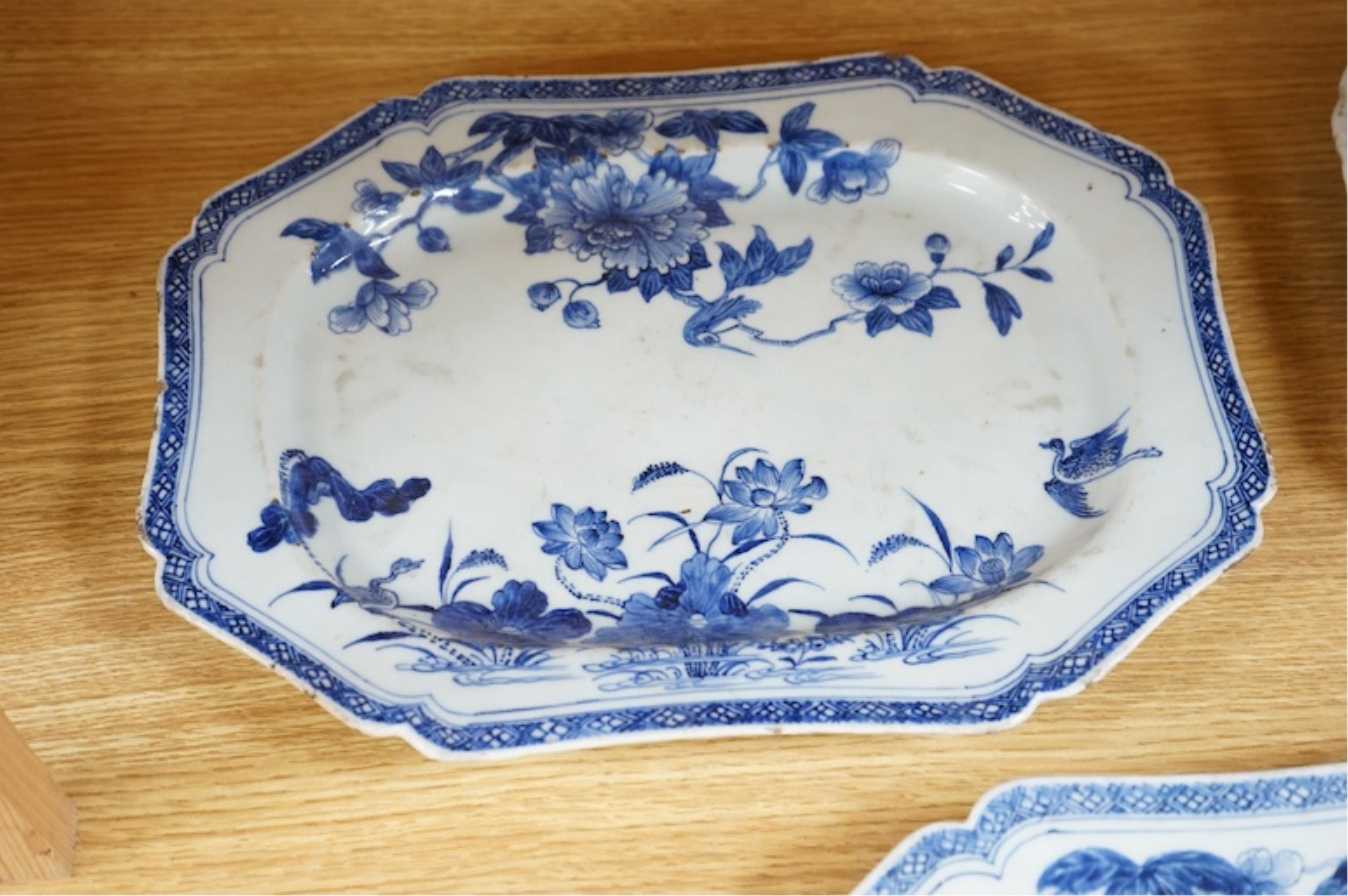 Three 18th century Chinese export blue and white dishes, two decorated with Lotus and peonies, the third with figures in a river landscape scene, Condition - fair to good